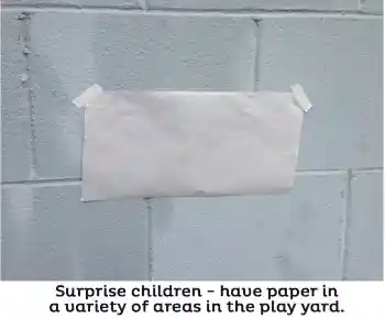 large white paper taped to outdoor wall for outdoor art activity