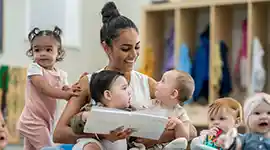 young children listening to teacher read in a classroom