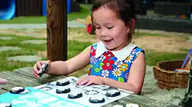 Girl playing with coding penguins