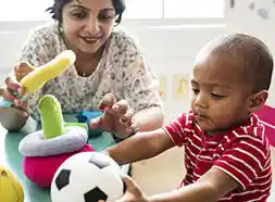 Toddler child playing with teacher