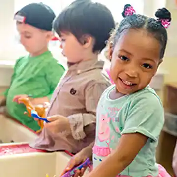 Preschool children playing at sand & water table