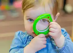 Toddler looking through leaf magnifier