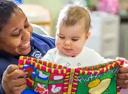 Teacher reading to an infant