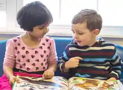 Preschool children reading a book